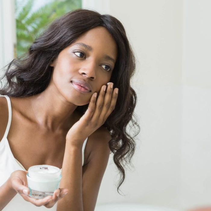 Young woman applying moisturizer